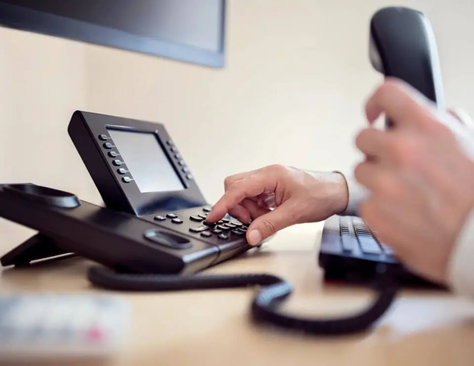 Businessman's Hand Dialing Telephone Number To Make Phone Call